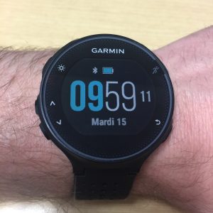 Garmin: Garmin round-faced watch showing time and date on a person's wrist.