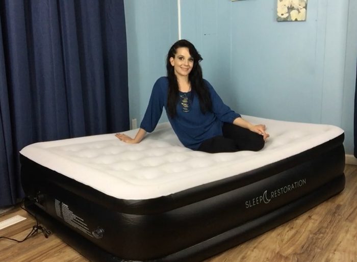 A woman sitting on a Sleep Restoration airbed, one of the best airbeds you can find on the market. There are tons of choices out there. How do you find the best air bed? Easy, consider your specific requirements for an air bed. How exactly are you going to use the air bed? Where are you going to put it? Who's going to use the air bed?