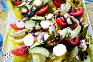 Colorful vegetable and fruit salad, featuring vibrant greens, reds, and yellows, tossed in a light vinaigrette dressing.