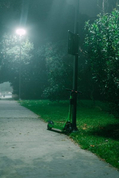 Scooter left by the lamp post at night.