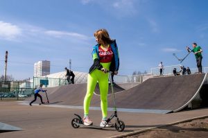 A woman with neon pants in a sunny day.