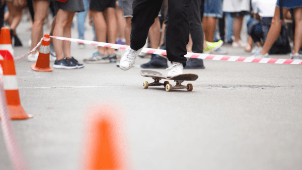 A person rides his skateboard for fun while in the middle of a group of people. 