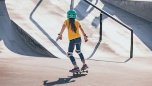 A kid riding an electric long-range skateboard, skateboarding. 