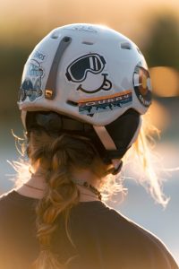 A girl with a braided ponytail wearing a decorated white head gear. 